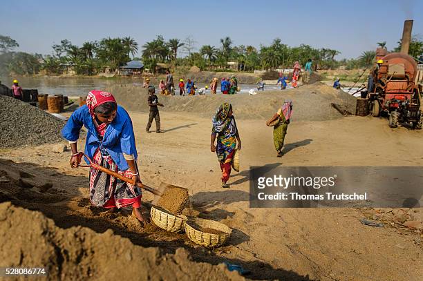 Women work on a site for the poduction of material for the road construction on April 11, 2016 in Khulna, Bangladesh.