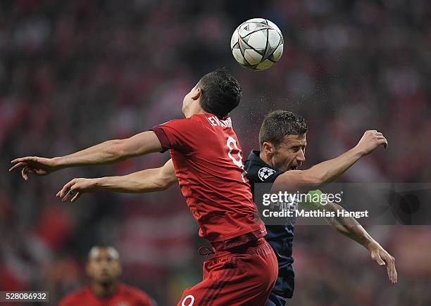 Robert Lewandowski of Muenchen jumps for a header with Gabi of Madrid during the UEFA Champions League semi final second leg match between FC Bayern...