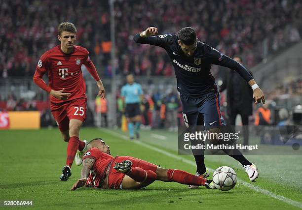 Yannick Carrasco of Madrid is challenged by Arturo Vidal of Muenchen during the UEFA Champions League semi final second leg match between FC Bayern...
