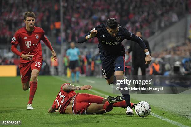 Yannick Carrasco of Madrid is challenged by Arturo Vidal of Muenchen during the UEFA Champions League semi final second leg match between FC Bayern...