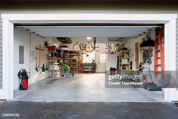 man in garage - garage doors stock pictures, royalty-free photos & images