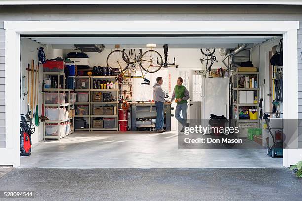 men talking in garage - garage doors stock pictures, royalty-free photos & images