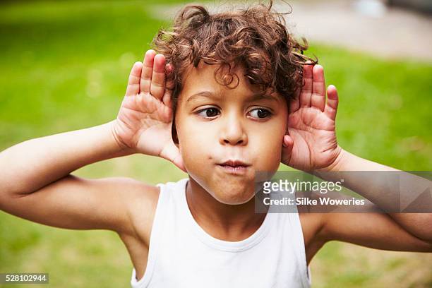 boy (4-5) making faces - listening stock-fotos und bilder