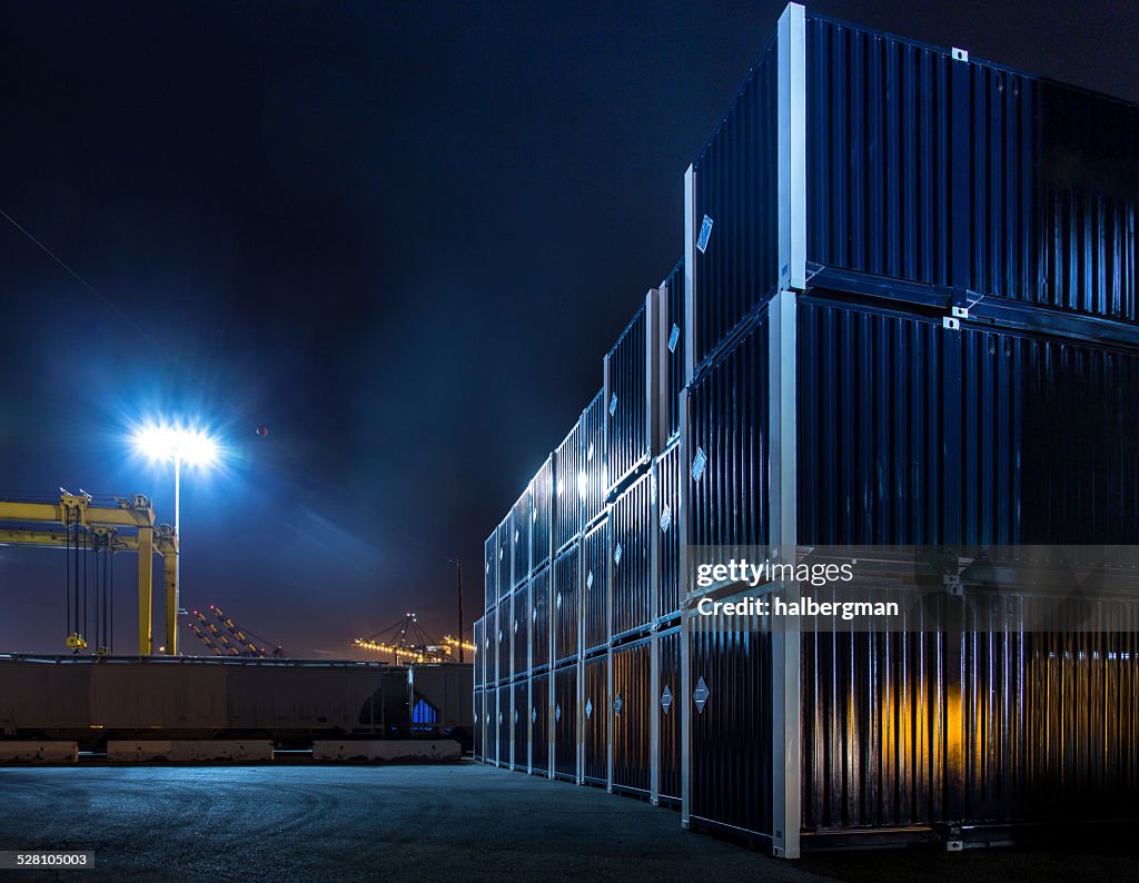 Stacked Shipping Containers in Dockyard at Night