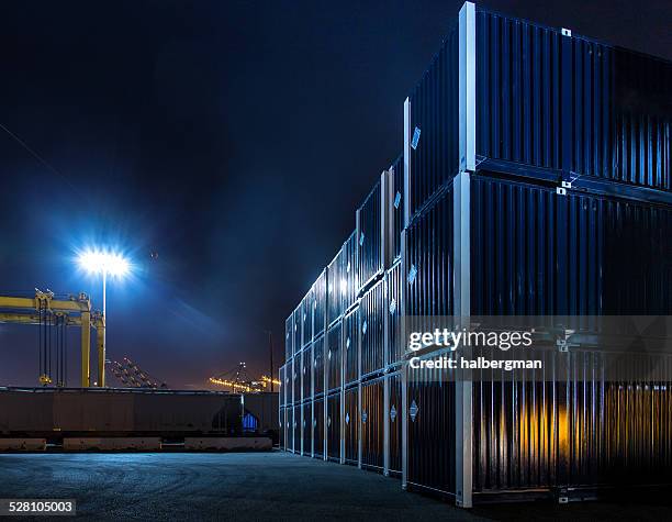 stacked shipping containers in dockyard at night - behållare bildbanksfoton och bilder