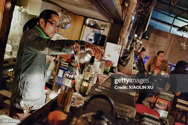 At March 1 Kirikiri, Otsuchi, Iwate, Japan. The owner of bar "APE", Norishige, are mixing cocktail for the guests. 35-year-old Norishige with glasses...