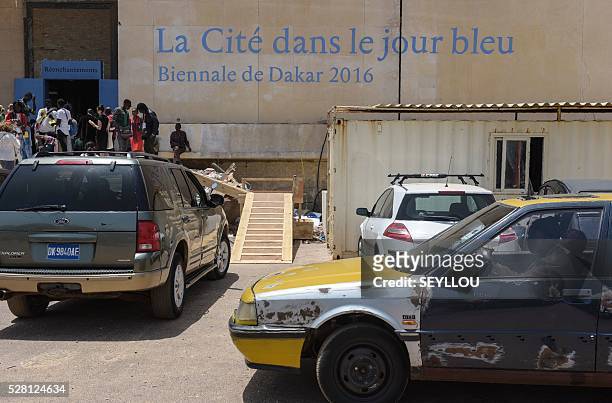 Taxi drives past the Ancien palais de Justice exhibition placeon the opening day of Dak'Art, the biennale of contemporary African art, in Dakar on...