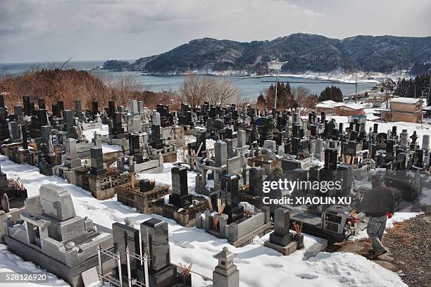 At 27 February 2012, Kirikiri, Otsuchi, Iwate, Japan In the cemetery besides Kichijoji Temple, two workers are building tombstones for the victims of...