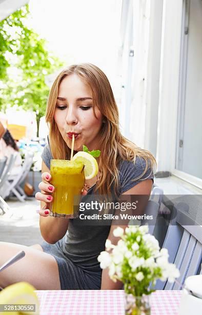 woman sitting in small cafe on sunny day - berlin cafe stock pictures, royalty-free photos & images