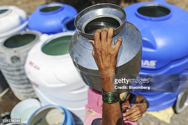 Woman carries a water container on her head filled from public drums at a village in Beed district, Maharashtra, India, on Friday, April 15, 2016....