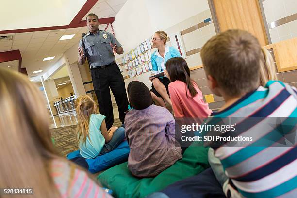 police or school security officer speaking to young students - guarding stock pictures, royalty-free photos & images