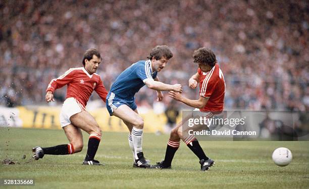 Brighton player Jimmy Case is tackled by Ray Wilkins and Bryan Robson of Manchester United during the 1983 FA Cup Final at Wembley Stadium on May 21,...