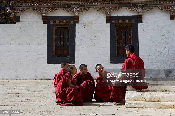 young monks talking at tashing monastery - bhutan monk stock pictures, royalty-free photos & images