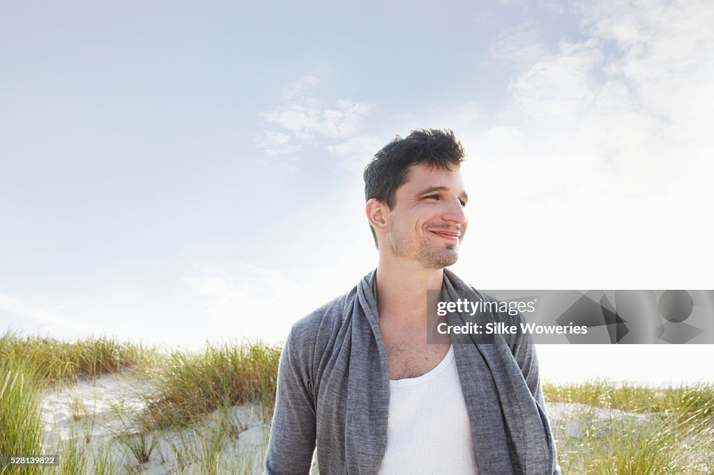 Portrait of a content and happy man at the beach daydreaming