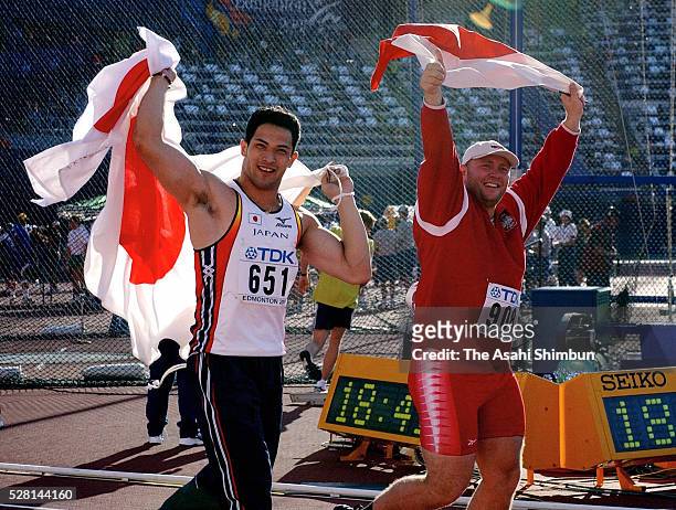 Silver medalist Koji Murofushi of Japan and gold medalist Szymon Ziolkowski of Poland applaud supporters after the Men's Hammer Throw during the IAAF...