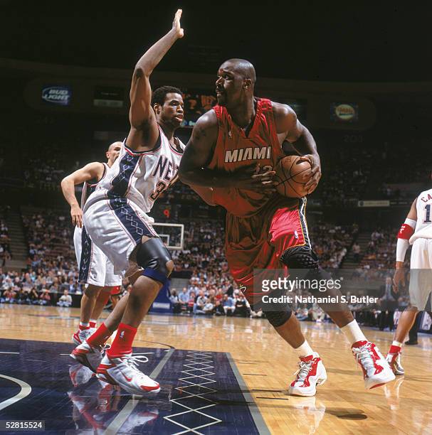Shaquille O'Neal of the Miami Heat drives to the basket against Jason Collins of the New Jersey Nets in Game four of the Eastern Conference...