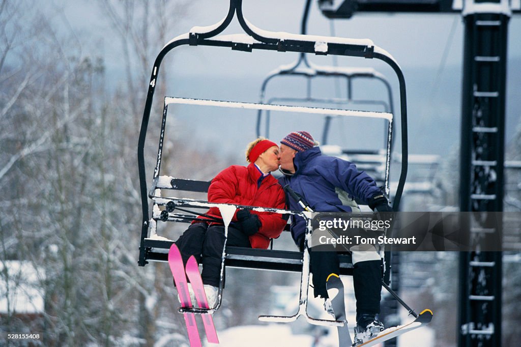 Skiers Kissing on Chair Lift