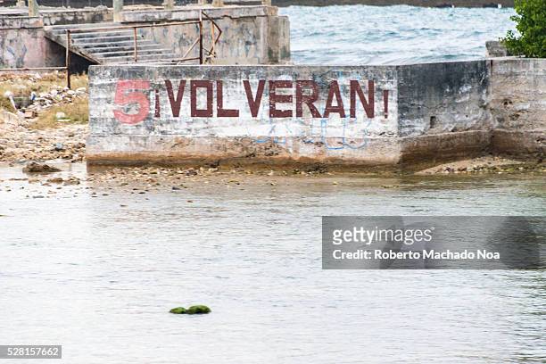 The Cuban Five: Propaganda in a sea wall in Miramar reading "They Will Be Back" referring to the five Cubans spies imprisoned in the US.
