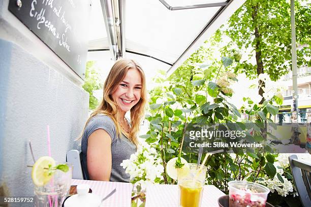 woman sitting in small cafe on sunny day - berlin cafe stock pictures, royalty-free photos & images