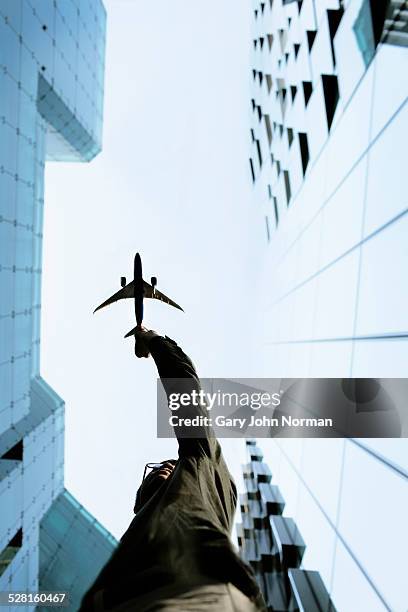 businessman reaching up to sky towards plane - aircraft skyscrapers stockfoto's en -beelden