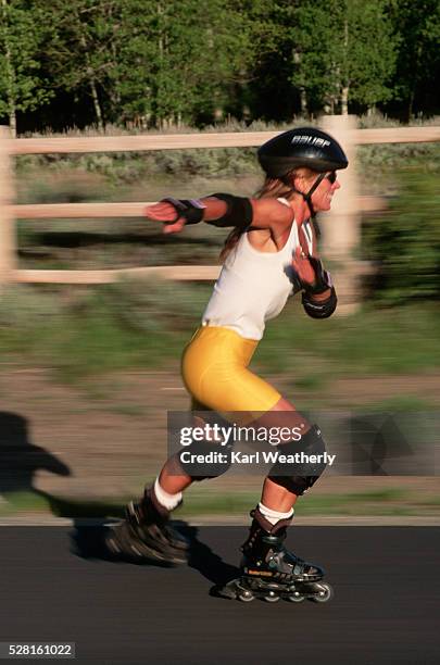 woman inline skating on road - 90s rollerblading fotografías e imágenes de stock