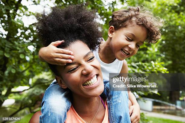 mother with son (4-5) in park - piggy back and men only stockfoto's en -beelden