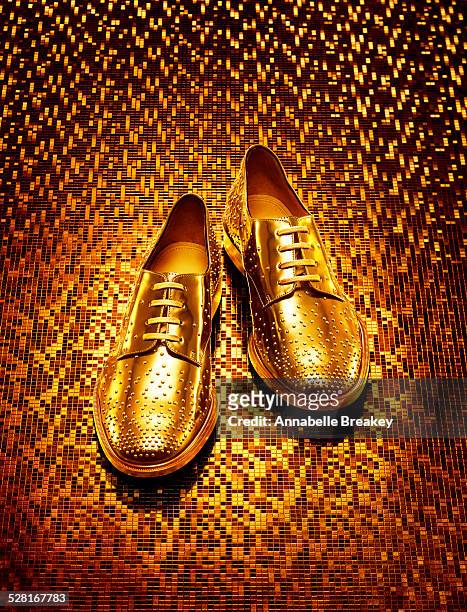 gold men's oxfords on gold background - gold shoe stock-fotos und bilder