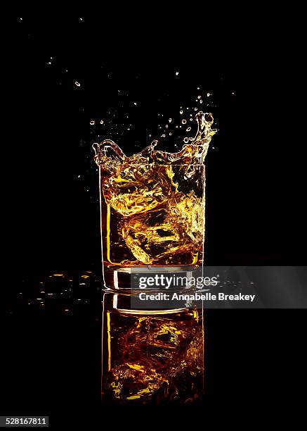 whiskey splash on black - whisky cocktails stock pictures, royalty-free photos & images