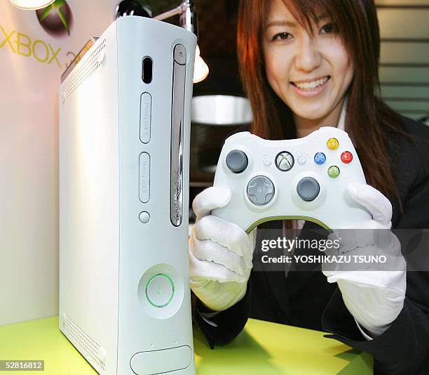 Microsoft's employee displays the console and wireless controler of Microsoft's next generation video game console "Xbox 360", equipped with IBM's...