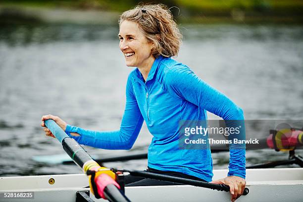 Smiling woman in rowing shell during practice