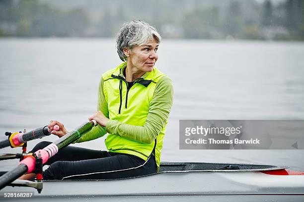 smiling mature female rower looking over shoulder - best animated short film stock-fotos und bilder