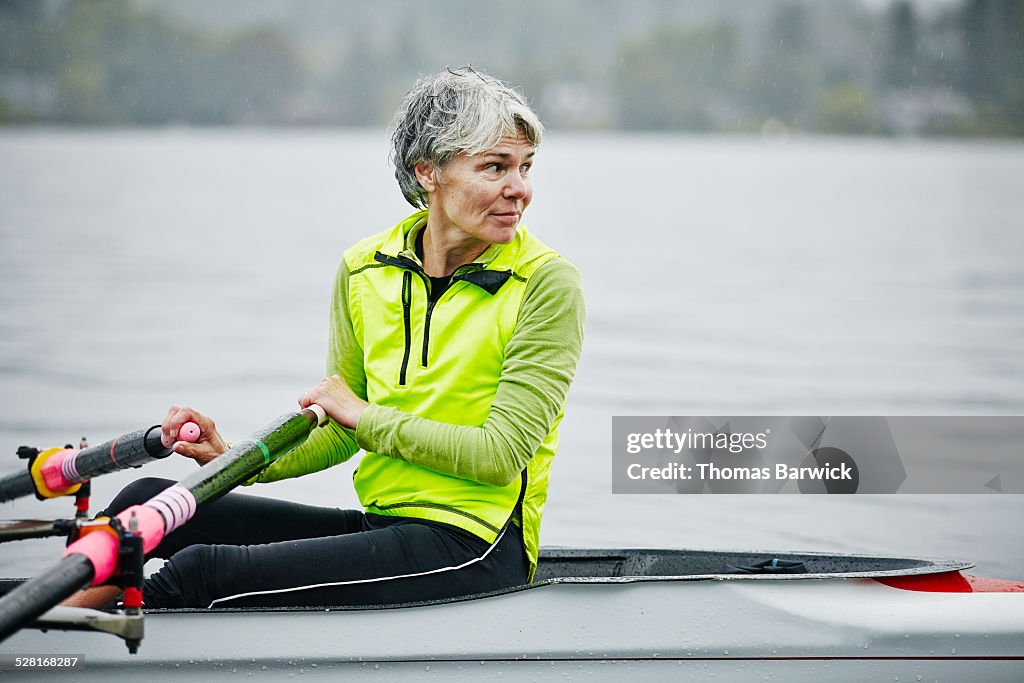 Smiling mature female rower looking over shoulder