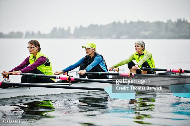 Group of mature female rowers practicing in rain