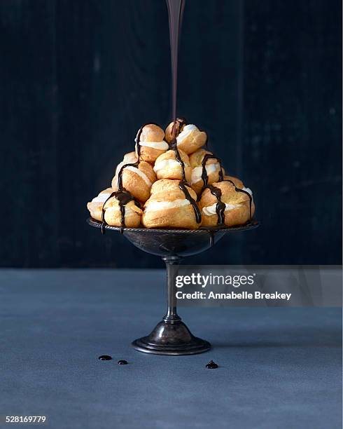 profiteroles chocolate drizzle pour - profiterole stock-fotos und bilder