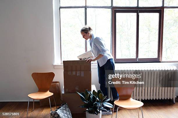 woman unpacking in new loft - woman on the move stock pictures, royalty-free photos & images