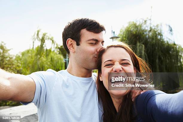 portrait of couple taking selfie in park - vrouwen 32 jaar samen kus stockfoto's en -beelden