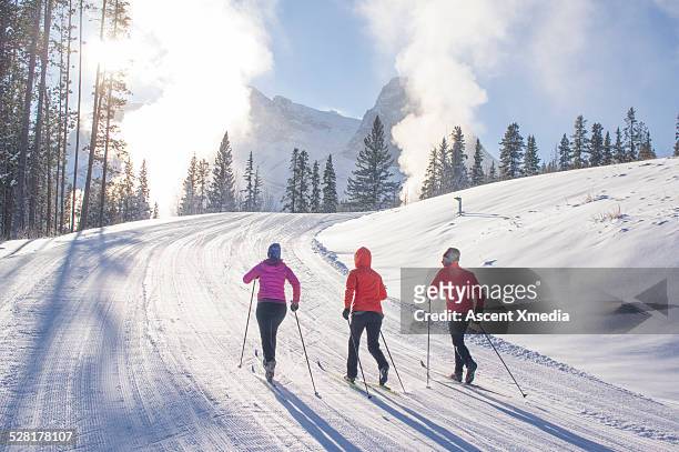 nordic skiers ascend ski track on very cold day - nordic skiing event fotografías e imágenes de stock