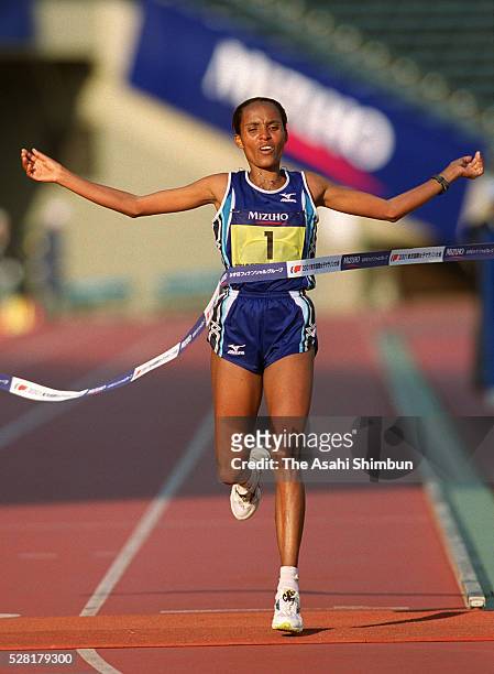 Derartu Tulu of Ethiopia crosses the finishing tape to win the Tokyo International Women's Marathon at the National Stadium on November 18, 2001 in...