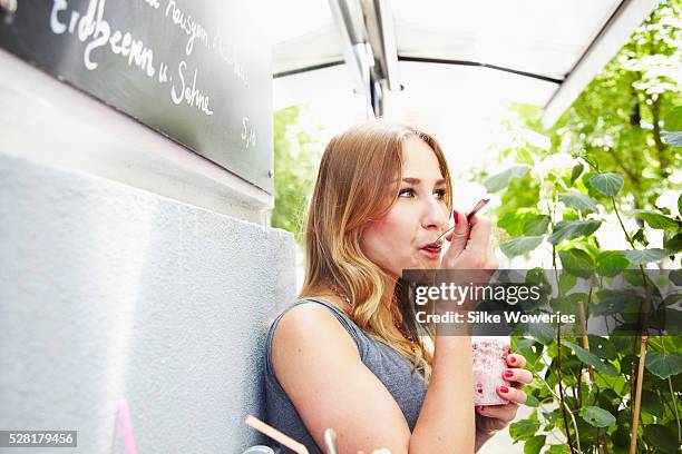 woman having breakfast in small cafe on sunny day - yoghurt spoon stock pictures, royalty-free photos & images