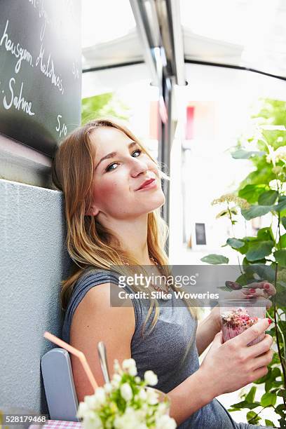 woman having breakfast in small cafe on sunny day, - berlin cafe stock pictures, royalty-free photos & images