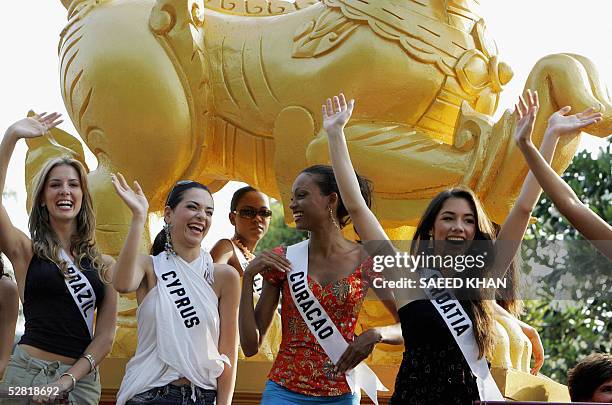 Miss Universe 2005 contestants, Miss Brazil Crina Beduschi , Miss Cyprus Helen Hatjidimetriuo and Miss Croatia Jelena Glisic wave as they participate...