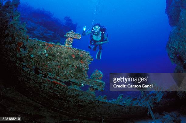 scuba diver exploring sunken ship - scuba regulator stock pictures, royalty-free photos & images