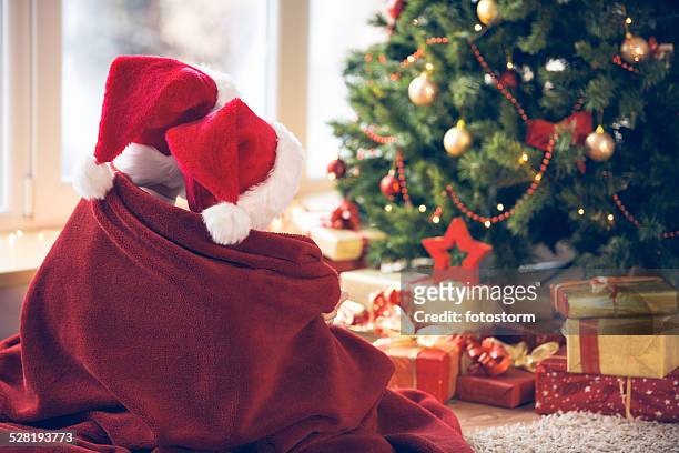 children waiting for christmas by the tree - brother blanket stockfoto's en -beelden