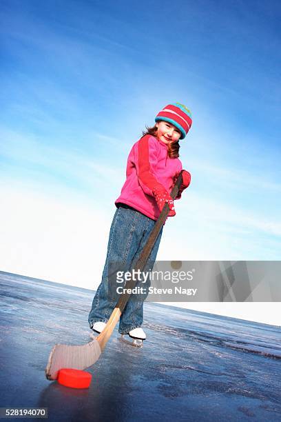 girl with hockey stick and puck - kids ice hockey stock pictures, royalty-free photos & images