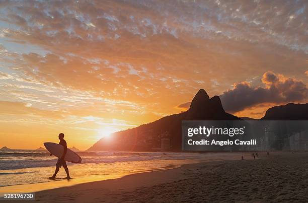 surfer on beach at sunset, ipanema, rio de janeiro, brazil - rio de janeiro beach stock pictures, royalty-free photos & images