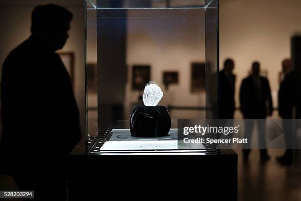 Guards stand next to the 1109-carat rough Lesedi La Rona diamond, the biggest rough diamond discovered in more than a century, at Sotheby's on May...