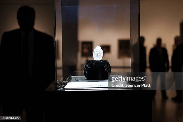 Guards stand next to the 1109-carat rough Lesedi La Rona diamond, the biggest rough diamond discovered in more than a century, at Sotheby's on May...