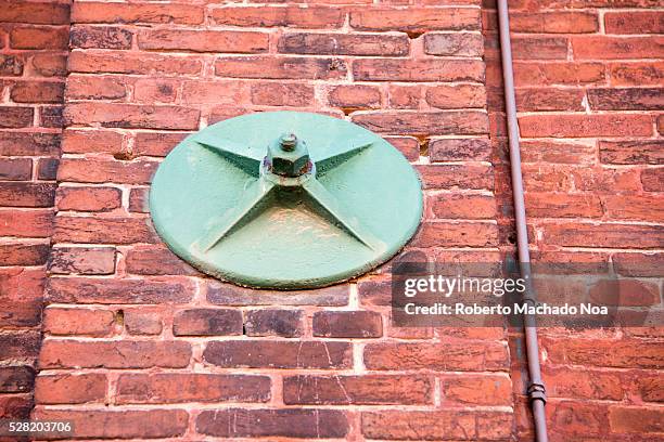 Distillery district: architecture detail of red brick column secured by large metal screw. The location is a heritage site and major tourist landmark.