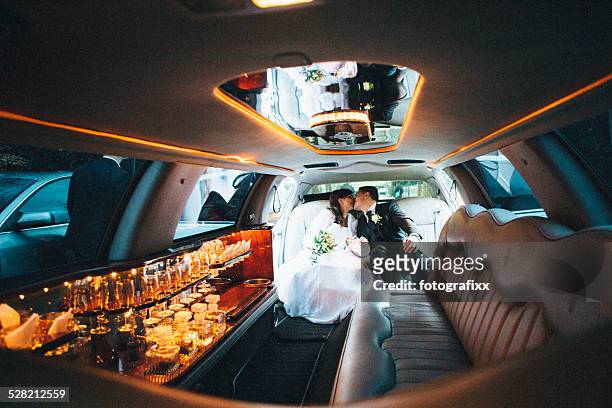 just married: bride and groom sitting in a stretch limousine - limo stockfoto's en -beelden