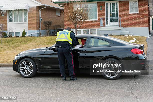 Toronto Police Service officer, giving a speeding ticket to a driver parked on the side of the road.